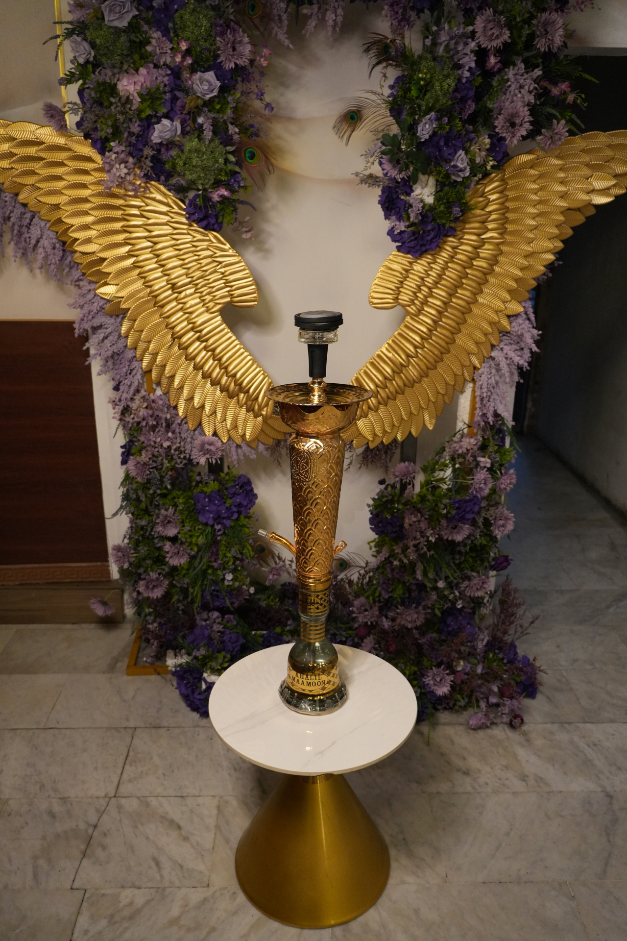 Gold shisha display with wings backdrop