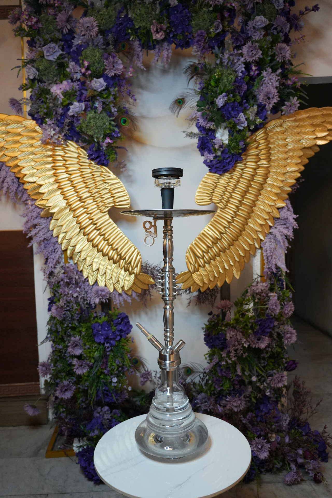 Shisha in front of floral gold wings
